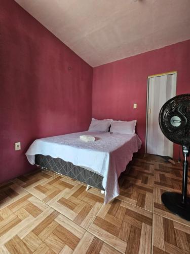 a bedroom with a bed and a wooden floor at Pousada Brilho do Mar in Guriú
