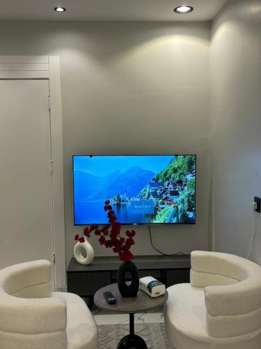 Una sala de estar con dos sillas y un televisor de pantalla plana. en #3 Daily Rental Studio in Sulaymaniyah, en Riad