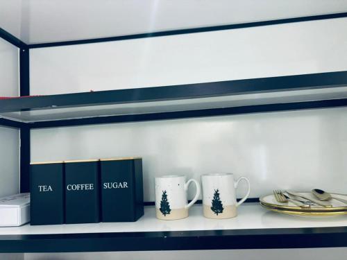 dos tazas de café sentadas en un estante en una cocina en #3 Daily Rental Studio in Sulaymaniyah, en Riad