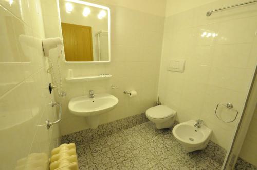 a bathroom with a sink and a toilet and a mirror at Santorsola Relax Hotel in Sant’Orsola