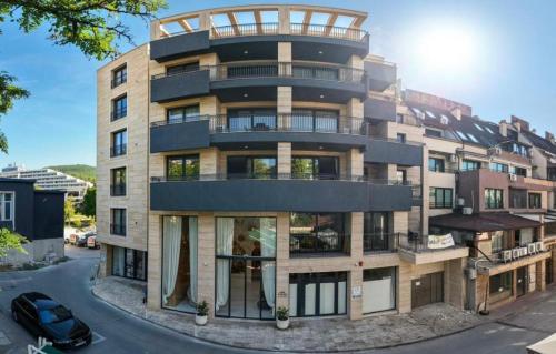 a tall building with a car parked in front of it at Center Park Apartment in Sandanski