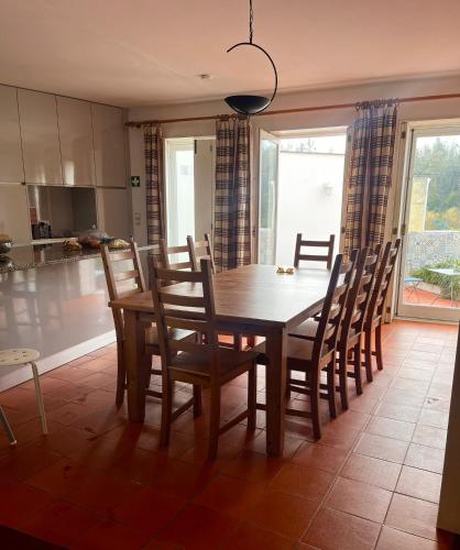 a dining room with a wooden table and chairs at Citrus Tree House, private pool and garden. in Angeja