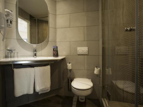 Un baño con inodoro, lavabo y espejo. en Ibis Abdelmoumen Casa Centre, en Casablanca