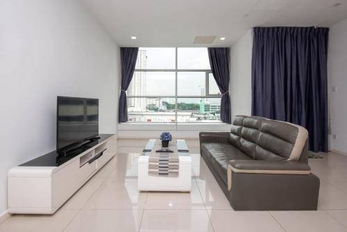 un soggiorno con divano e TV a schermo piatto di Bright 2BR Suasana Stay Near JB Sentral CIQ a Johor Bahru