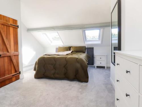 ein Schlafzimmer mit einem Bett auf einem Dachboden in der Unterkunft Gardener's Cottage in Lytham St Annes