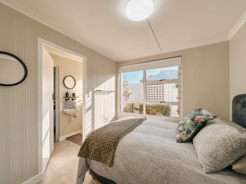 a bedroom with a bed and a large window at Cooper 4 in Agulhas
