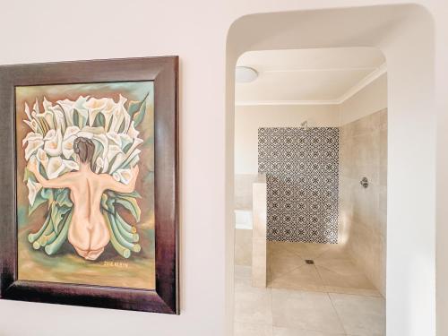 a painting of a woman on a wall next to a bathroom at Cooper 4 in Agulhas