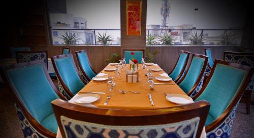 a table in a restaurant with blue chairs at Hotel Seven Hills Tower in Agra