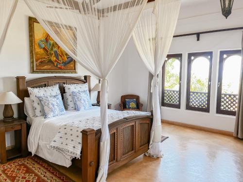a bedroom with a canopy bed with curtains at Vipingo Ridge, The Maridi Villa by Diplo El Homes in Pingilikani