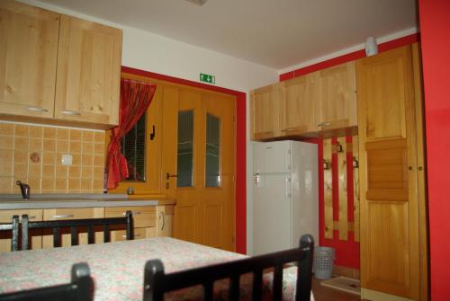 a kitchen with wooden cabinets and a white refrigerator at Apartment Beli Zajec in Mozirje