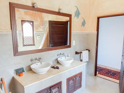 a bathroom with two sinks and a mirror at Vipingo Ridge, The Maridi Villa by Diplo El Homes in Pingilikani