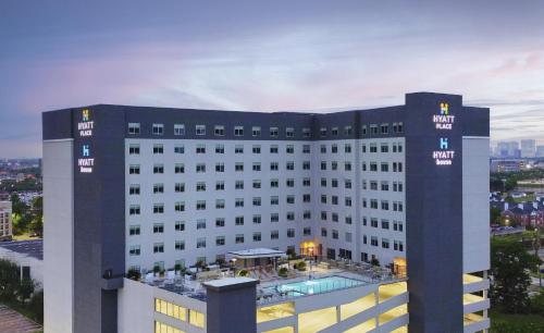 a large white building with a pool in front of it at Hyatt House Houston Medical Center in Houston