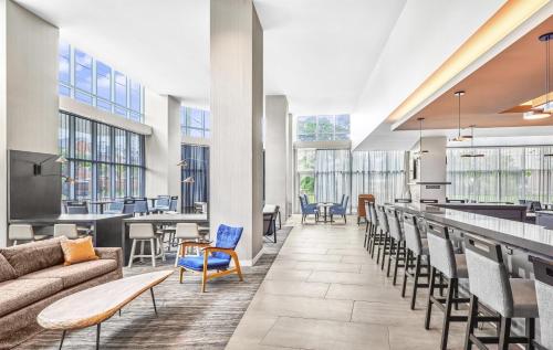 a lobby with a couch and chairs and a bar at Hyatt House Houston Medical Center in Houston