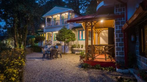 une maison avec une table et des chaises devant dans l'établissement Alaya Stays The Hive Cottage, à Nainital