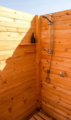 a bathroom with a shower in a wooden wall at Authentic Private Tent in Badīyah