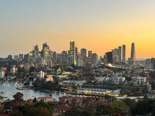 a view of a city with a river and buildings at JoJo's Sydney Escape - Breathtaking Harbour Bridge & Ocean Views, 2 Beds & free parking in Sydney