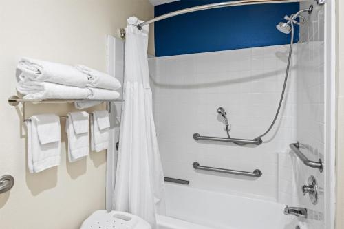 a bathroom with a shower and a toilet and towels at Spark by Hilton Fort Stockton in Fort Stockton