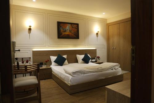 a bedroom with a bed and a desk and a chair at Siya Residency in New Delhi