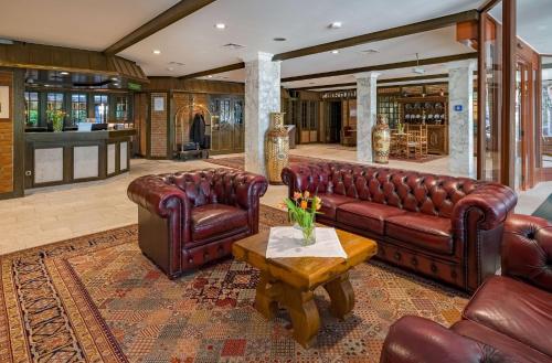 オルデンブルクにあるAspire Oldenburg, Trademark Collection by Wyndhamの革張りのソファとテーブルのあるリビングルーム