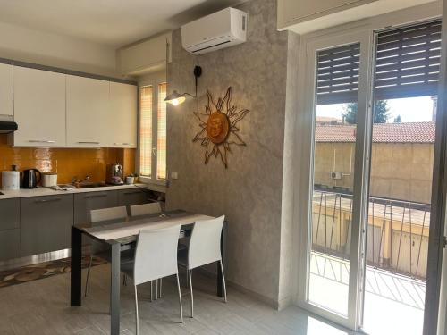 a kitchen with a table and chairs and a window at TheSun in Legnano