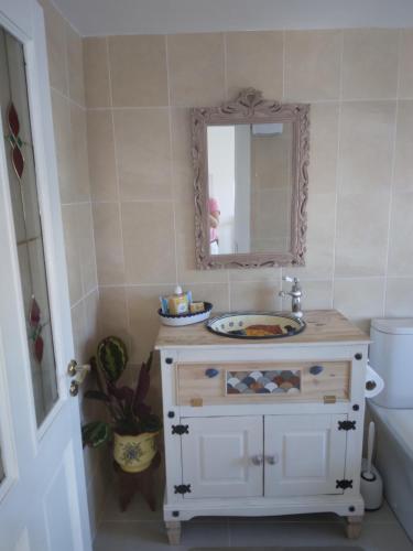 a bathroom with a sink and a mirror at Seod Na Mara, Jewel of the Sea, Upstairs Flat, Dun Geagan,Ballinskelligs in Ballinskelligs