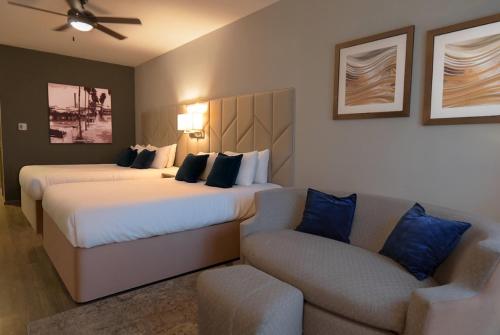 a hotel room with two beds and a couch at Esplendor by Wyndham Los Mochis Country Place in Los Mochis