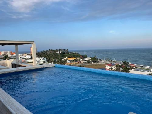 a large swimming pool with a view of the ocean at Luxury 2-Bedroom Apartment with amazing view - Infinity Pool and Rooftop in Building in Veracruz