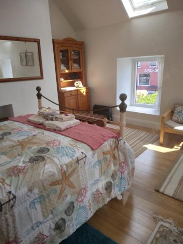 a bedroom with a bed and a window at Seod Na Mara, Jewel of the Sea, Upstairs Flat, Dun Geagan,Ballinskelligs in Ballinskelligs