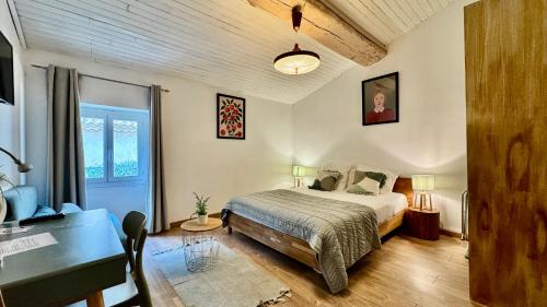 una camera da letto con un letto, una scrivania e un tavolo di Hotel Le Galambre a Nîmes