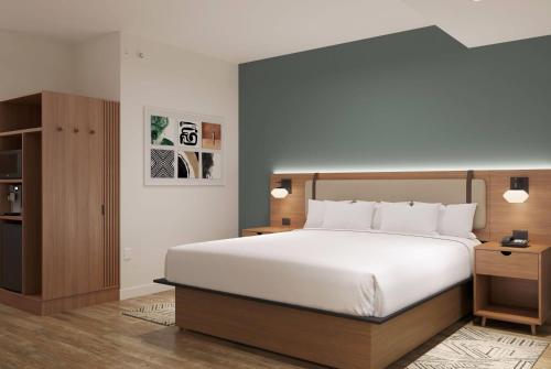 a bedroom with a large white bed and a cabinet at La Quinta Inn & Suites by Wyndham Tracy in Tracy