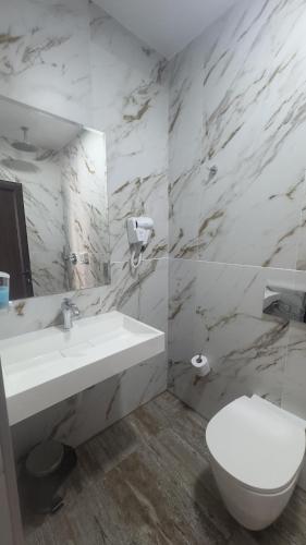 ein weißes Badezimmer mit Waschbecken und Toilette in der Unterkunft Hotel Garden in Widin
