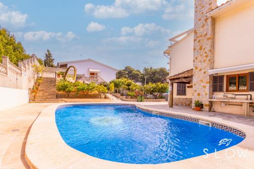 a swimming pool in front of a house at Villa Maravillas by Slow Villas in Playa de Palma
