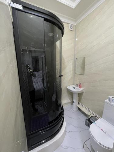 Un baño con ducha, inodoro y lavabo. en Shinam, en Samarkand
