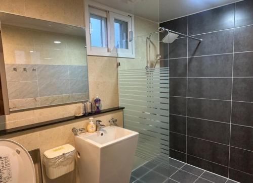 a bathroom with a toilet and a sink and a shower at 제주 웅장한 산방산뷰 사계2248 달무리동 감성숙소 in Sagye-ri