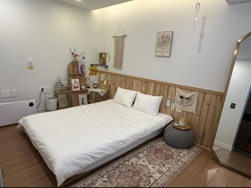 a bedroom with a bed with white sheets and a rug at 제주 웅장한 산방산뷰 사계2248 달무리동 감성숙소 in Sagye-ri