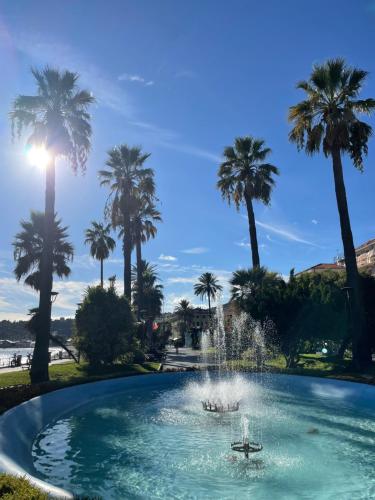 a fountain in a park with palm trees at Casa Della Baia With a beautiful view in Varazze
