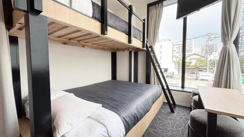 福岡市にあるHotel Edge Nakasuの二段ベッドと机のある寝室