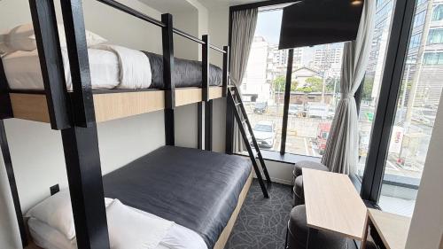 福岡市にあるHotel Edge Nakasuの二段ベッド3台と窓のある部屋