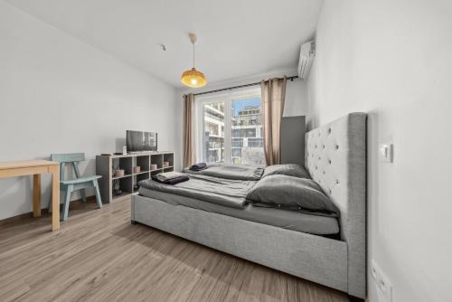 a bedroom with a bed and a desk and a window at Air conditioned 1 room Apartment, Slnečnice in Bratislava