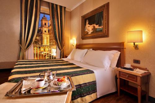 a hotel room with a bed with a tray of food on it at Colonna Hotel in Frascati