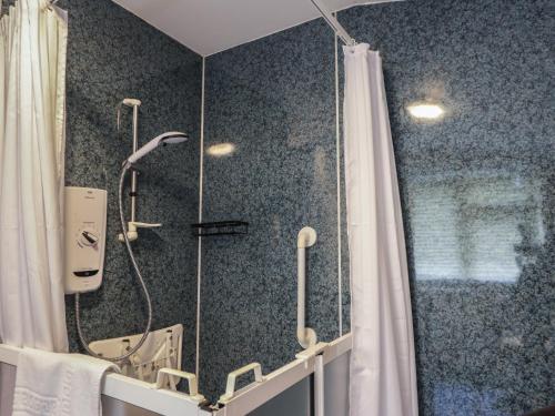 a bathroom with a shower with a shower curtain at Ivy House in Kingussie