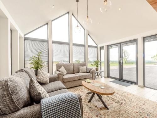 ein Wohnzimmer mit Sofa und Tisch in der Unterkunft Apple Blossom Cottage in Ludchurch