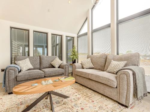 ein Wohnzimmer mit zwei Sofas und einem Couchtisch in der Unterkunft Apple Blossom Cottage in Ludchurch