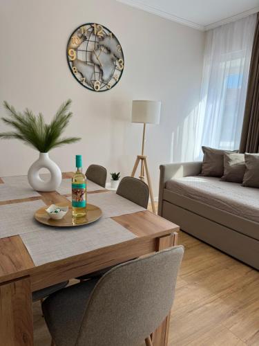 a dining room table with a bottle of alcohol on it at Európa Apartman Mini in Békéscsaba