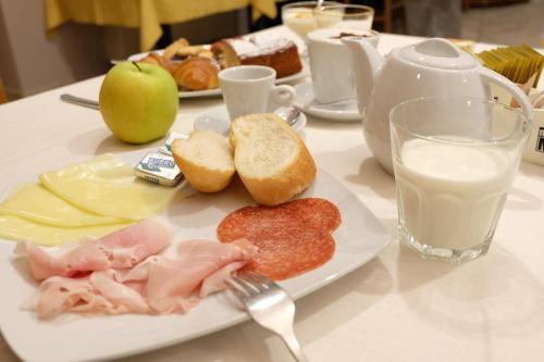 a table with a plate of food and a fork and milk at Santorsola Relax Hotel in Sant’Orsola