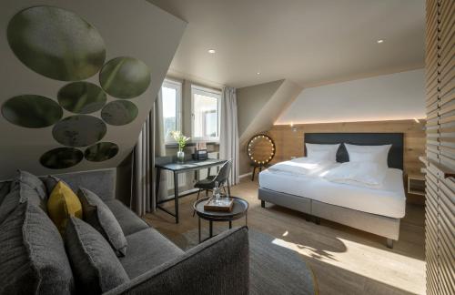 Un dormitorio con una cama y una sala de estar con un sofá. en Landhotel Weißes Roß, en Illschwang