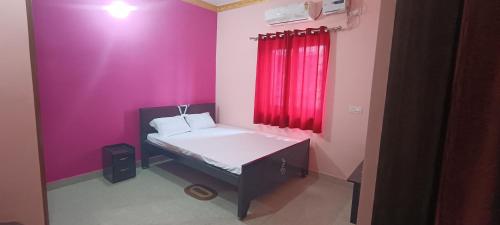 a small room with a bed with a red curtain at KR HOTEL AND BANQUET Hall in Dhanbād