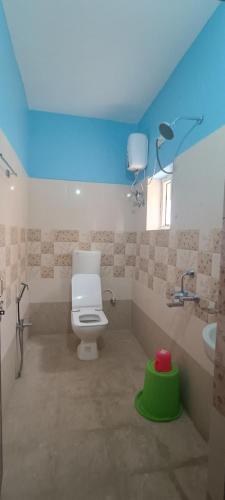 a bathroom with a white toilet and a sink at KR HOTEL AND BANQUET Hall in Dhanbād