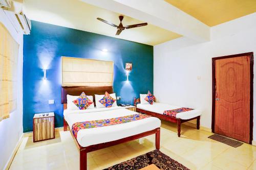 a bedroom with two beds and a blue wall at Via Elvin Balaji Beach Palace - 500m From Calangute Beach in Goa