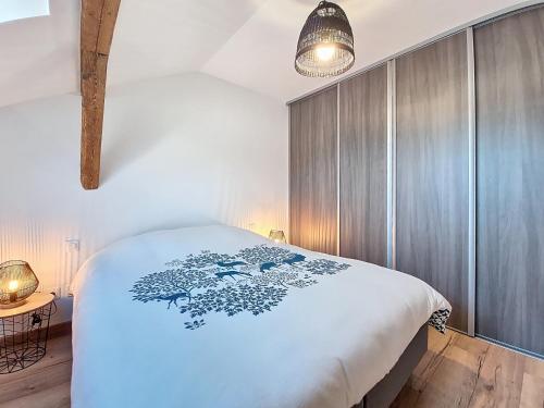 ein Schlafzimmer mit einem weißen Bett mit einem blauen Muster darauf in der Unterkunft L'ECRIN DU BONHEUR - Neuf - Tout confort - Parking - Proche de Strasbourg - Spacieux - Proche Transports in Stutzheim
